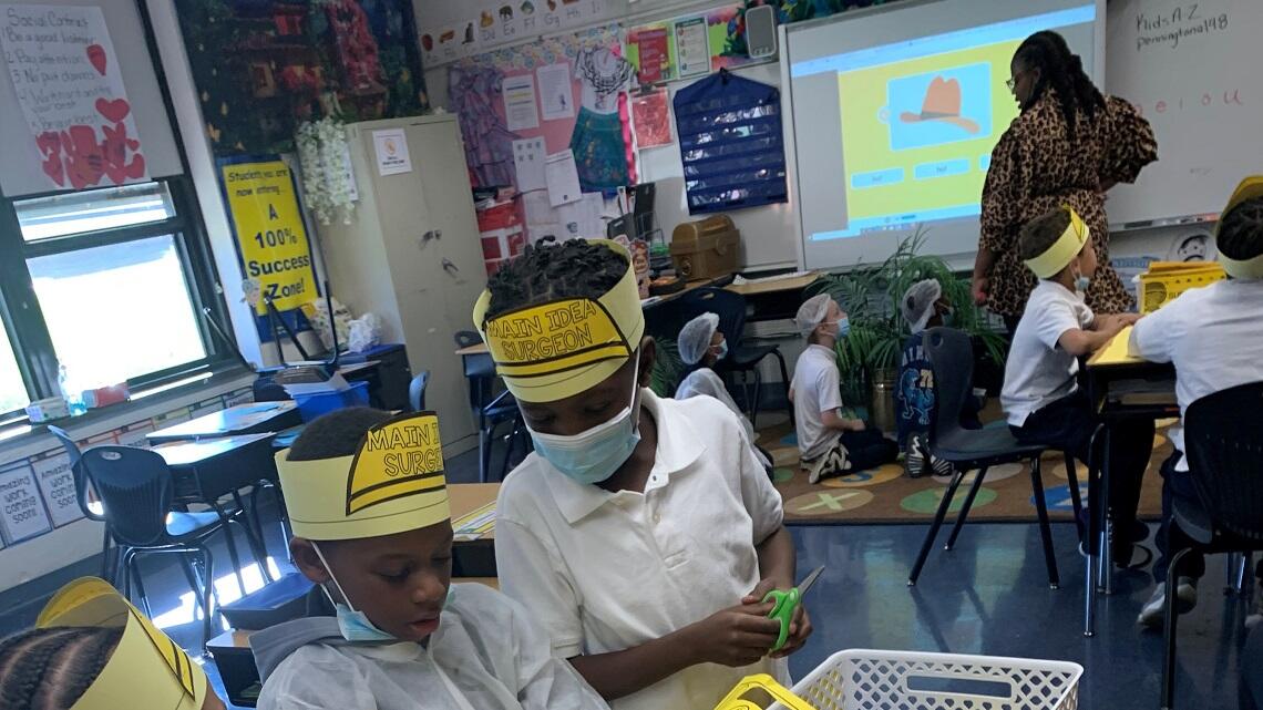 Students working in the classroom wearing fun hats